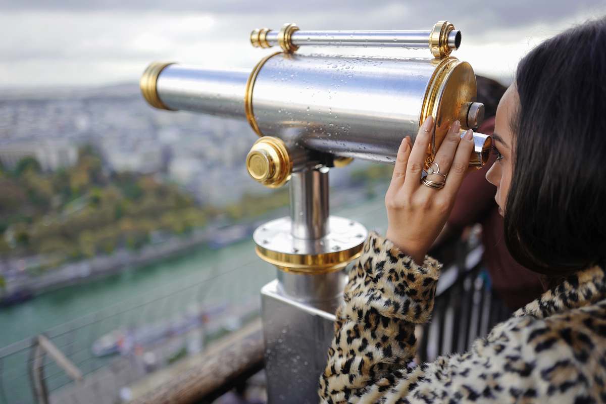 paris woman looking through a telescope during daytime france